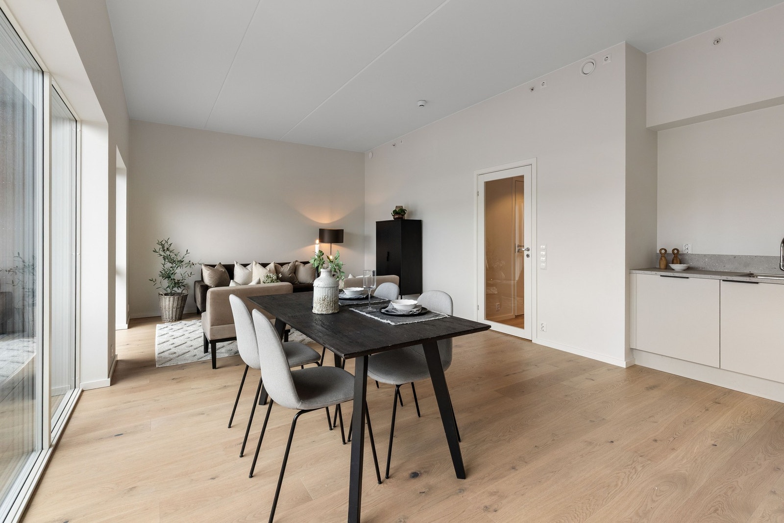 Romslig og sosial stue med åpen løsning mot kjøkkenet og god plass til et stort spisebord. Store vindusflater skaper en luftig og behagelig atmosfære i rommet. Galleribilde