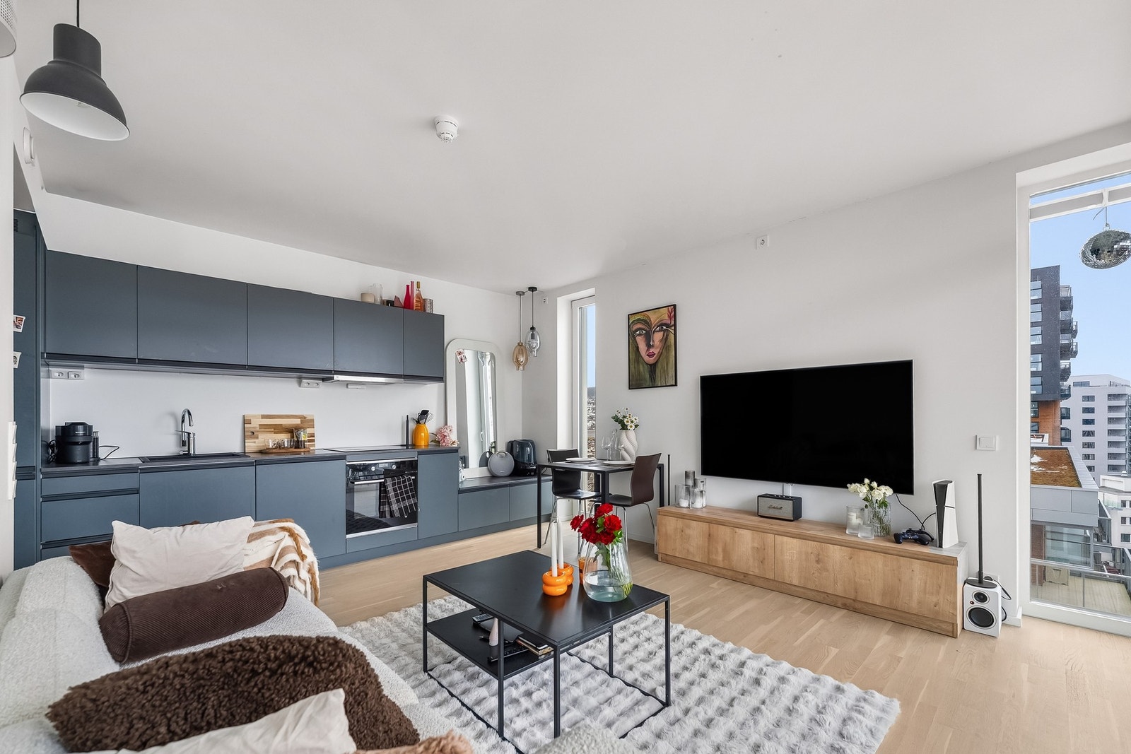 Det er en åpen stue- og kjøkkenløsning med store vindusflater som gir rikelig med lys Galleribilde