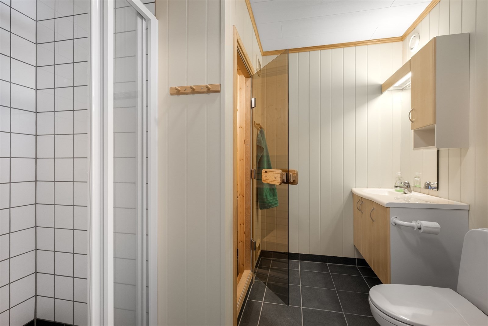 Badet har flislagt gulv m/ gulvvarme og flislagt dusjsone. Galleribilde