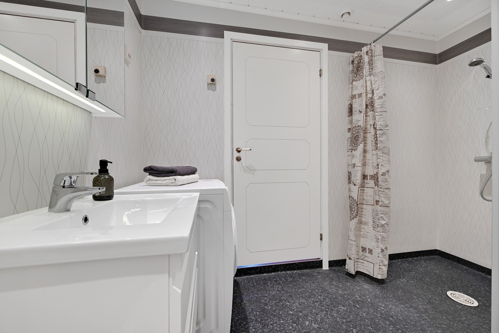 Dette badet er innredet med servant, wc, dusjnisje og opplegg for vaskemaskin. Galleribilde