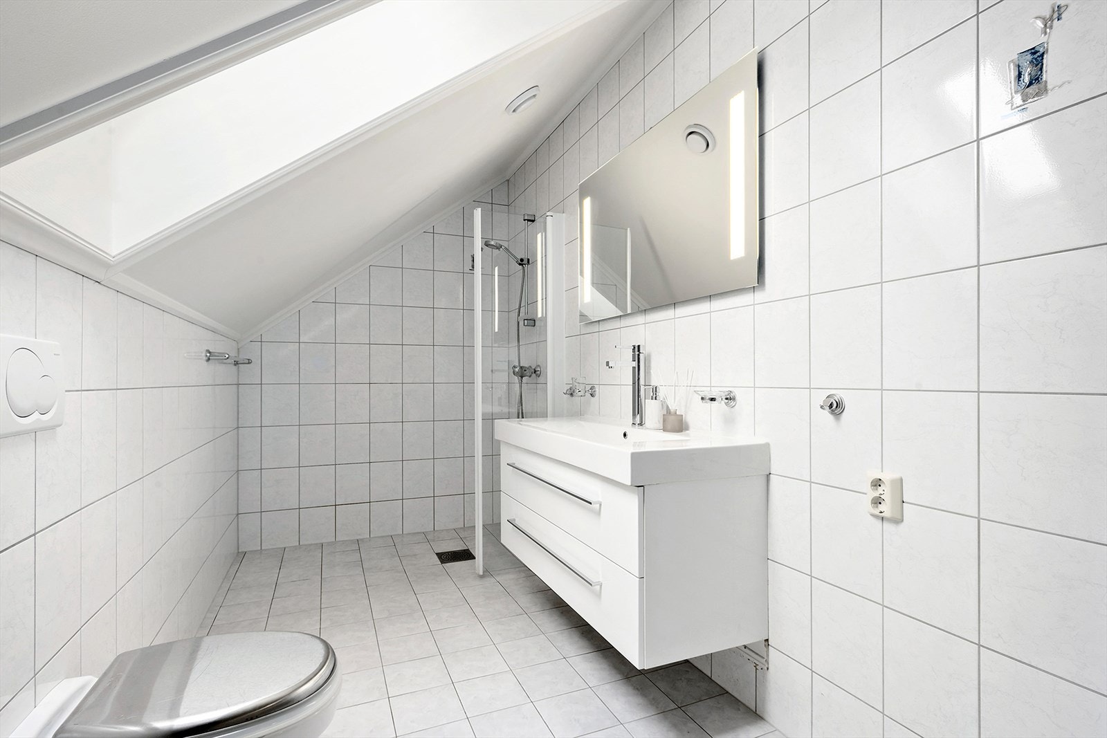 Badet har god størrelse og er innredet med wc, dusj og lekker servant med tilhørende skuffer. Galleribilde