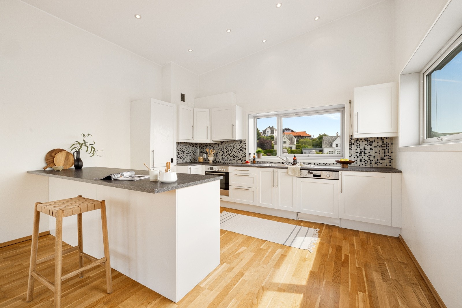 Kjøkkenet har innredning med profilerte fronter og benkeplate av laminat Galleribilde