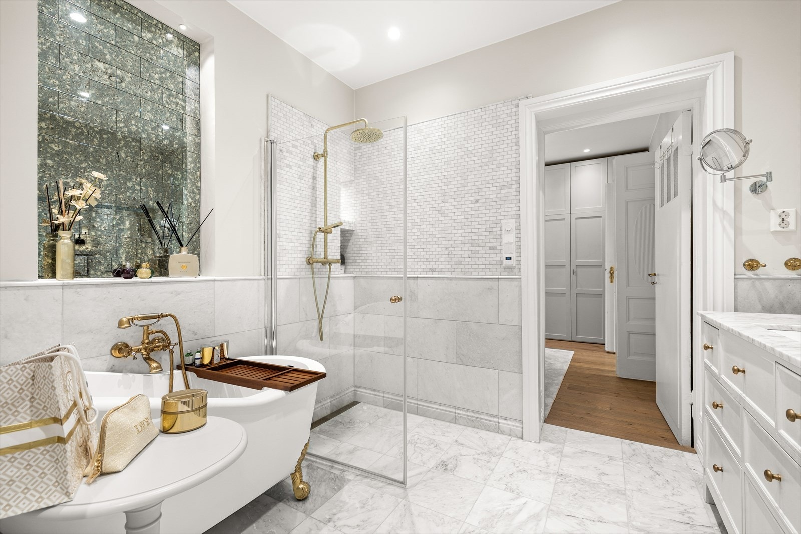 Det frittstående badekaret med dekorative gullføtter tilfører rommet et luksuriøst preg - en stilsikker kontrast til de rene linjene ellers i rommet. Galleribilde