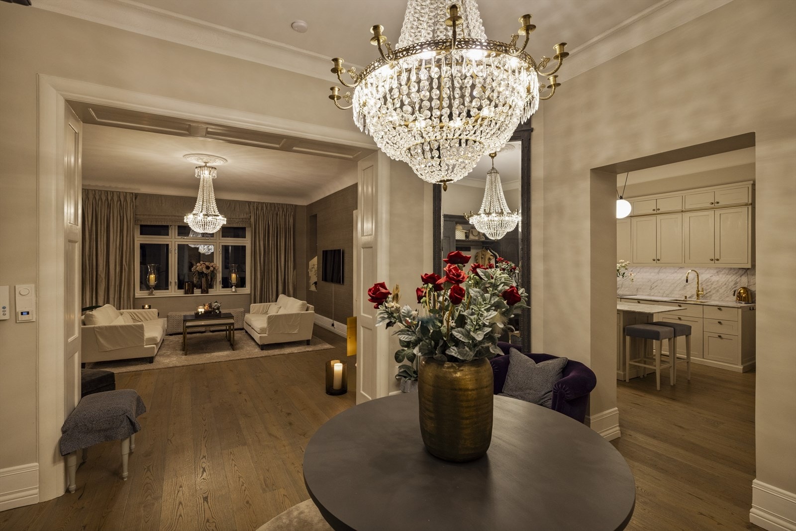 Lyset fra lysekronen hviler over den luftige hallen og skaper en lun og stilfull stemning - et inngangsparti som både imponerer og inviterer. Galleribilde