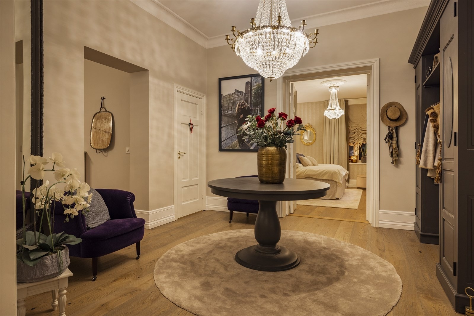 Kveldens lys spiller elegant i den store krystallysekronen og speiler seg i de klassiske overflatene - en velkomst som oser av kvalitet. Galleribilde