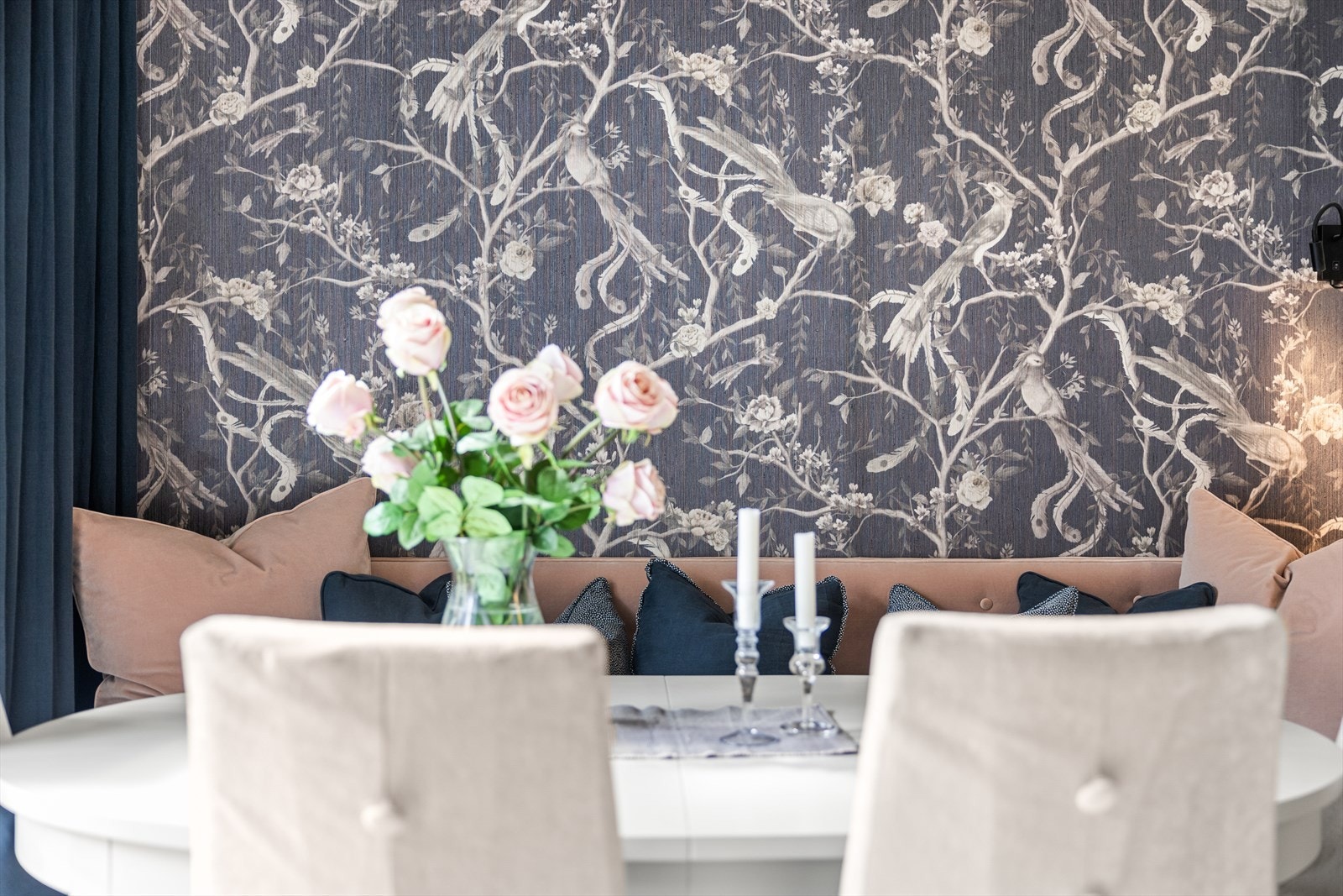 Interiøret er preget av dype blå velourgardiner og mønstret tapet - en harmonisk kontrast til kjøkkenets lyse marmor og mørke treverk. Galleribilde