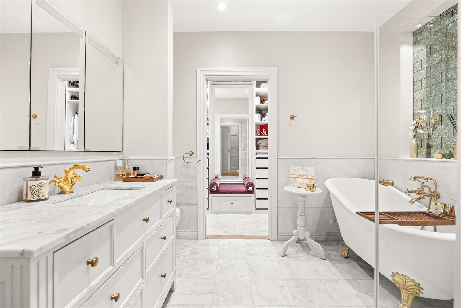 Videre beveger vi oss inn til et bad med spa-følelse - marmorfliser, varme gulv og klassisk eleganse gjør dette til et rom for ro og velvære. Galleribilde