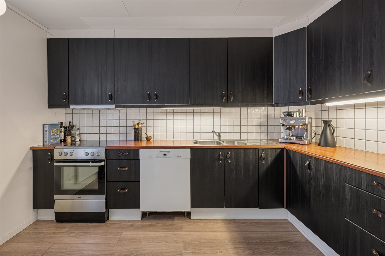 Innredningen har en laminert benkeplate, utstyrt med kjøkkenkran og dobbel kum. Galleribilde