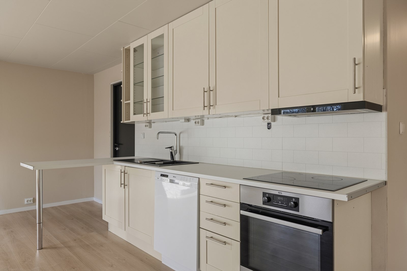 Kjøkkenet er utstyrt med platetopp, stekeovn, oppvaskmaskin og en nedfelt sort komposittvask. Galleribilde