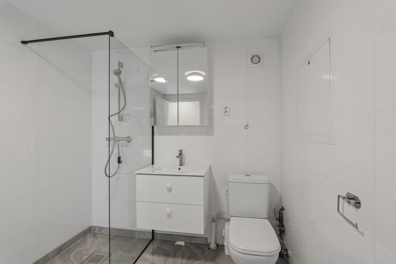 Badet er praktisk innredet med dusjnisje, håndkletørker og opplegg for vaskemaskin. Galleribilde