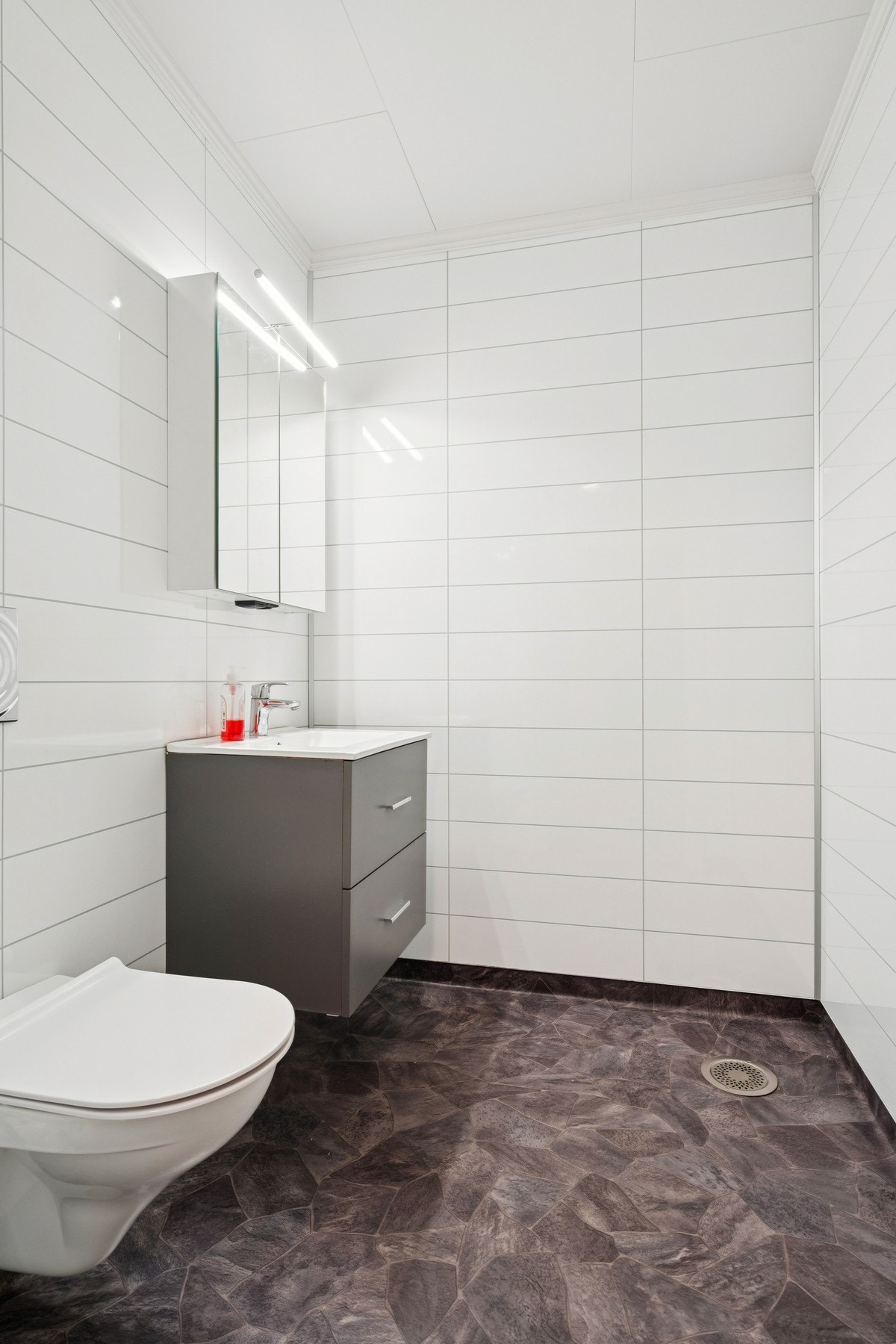 Praktisk toalettrom i første etasje, renovert i 2018, med vegghengt toalett og servant. Galleribilde