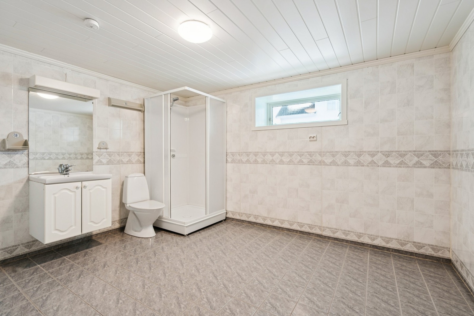 Rommet er utstyrt med toalett, dusjkabinett, servant og opplegg for vaskemaskin. Galleribilde