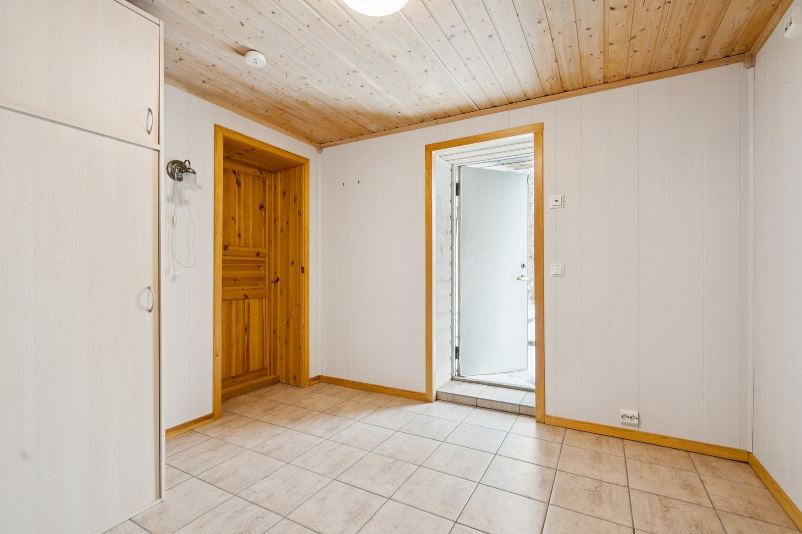 Underetasjen har også egen inngang via en enkel kjellerdør i tre. Galleribilde