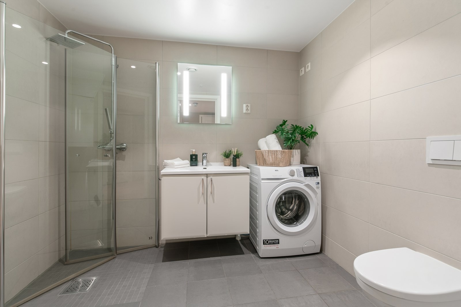 Tiltalende bad med opplegg for vaskemaskin og tørketrommel Galleribilde