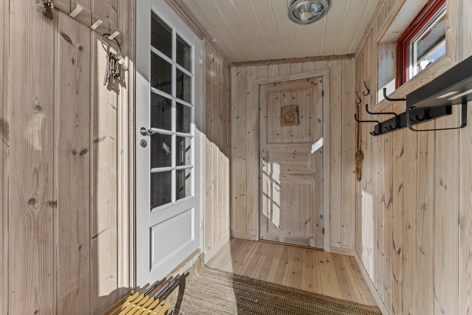 Innbydende entré med plass til å sette fra seg sko og henge fra seg yttertøy. Galleribilde