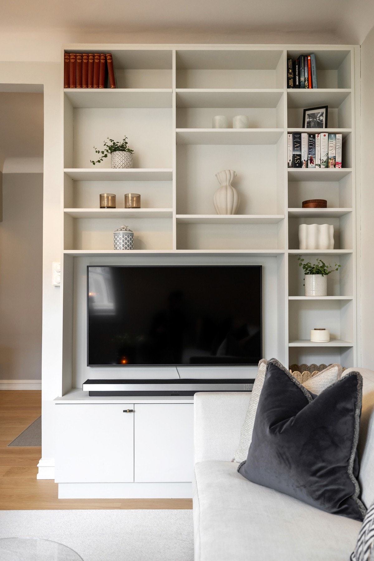 Stuen er innredet med plassbygde hyller som gir både praktisk oppbevaring og en pen innramming av TV-løsningen. Galleribilde