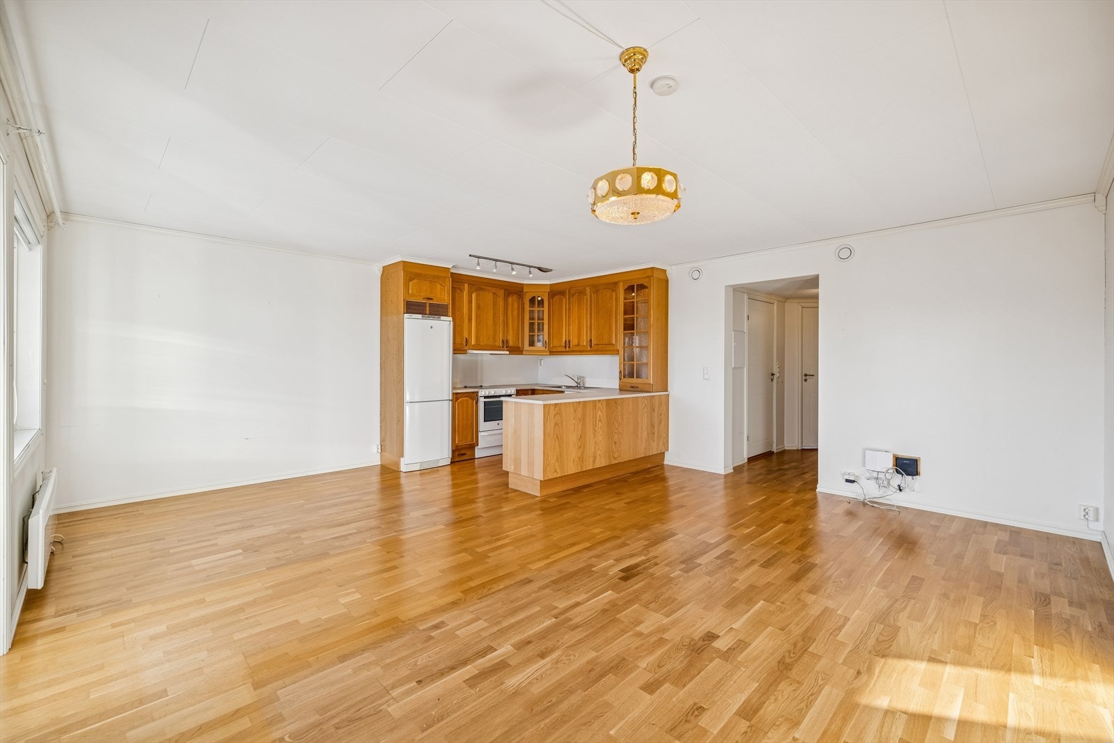 Stue og kjøkken i åpen løsning, med gjennomgående parkett på gulvet. Galleribilde