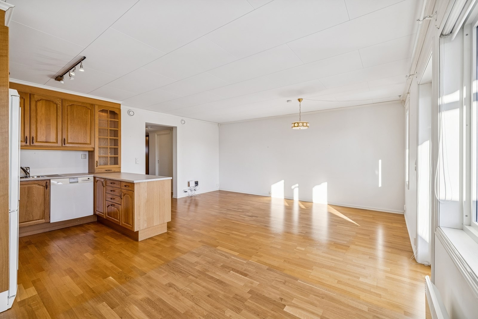 Stuen har god plass til både sofagruppe og spisebord. Kjøkkeninnredningen er fra Sigdal med profilerte eikefronter. Galleribilde