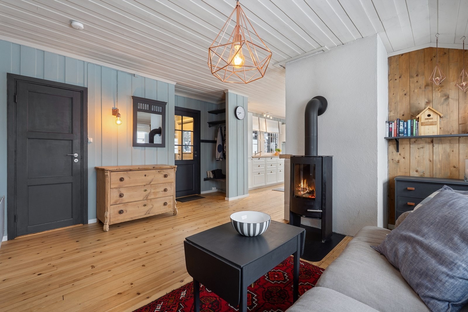 Vedovnen i stuen skaper lun og behagelig varme, perfekt for kalde vinterdager og koselige kvelder innendørs. Galleribilde