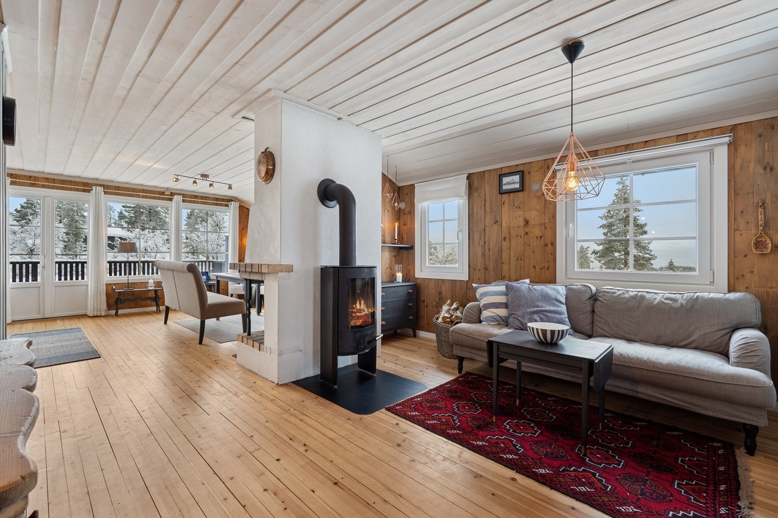 Stuen fremstår som lys og romslig, takket være de store vindusflatene som slipper inn rikelig med naturlig lys og skaper en luftig atmosfære. Galleribilde