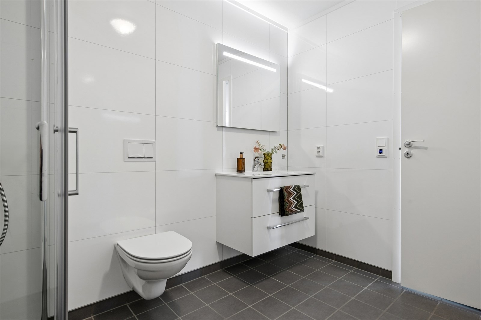 Badet har flislagt gulv med gulvvarme, vegghengt toalett og servant med underskap. Galleribilde