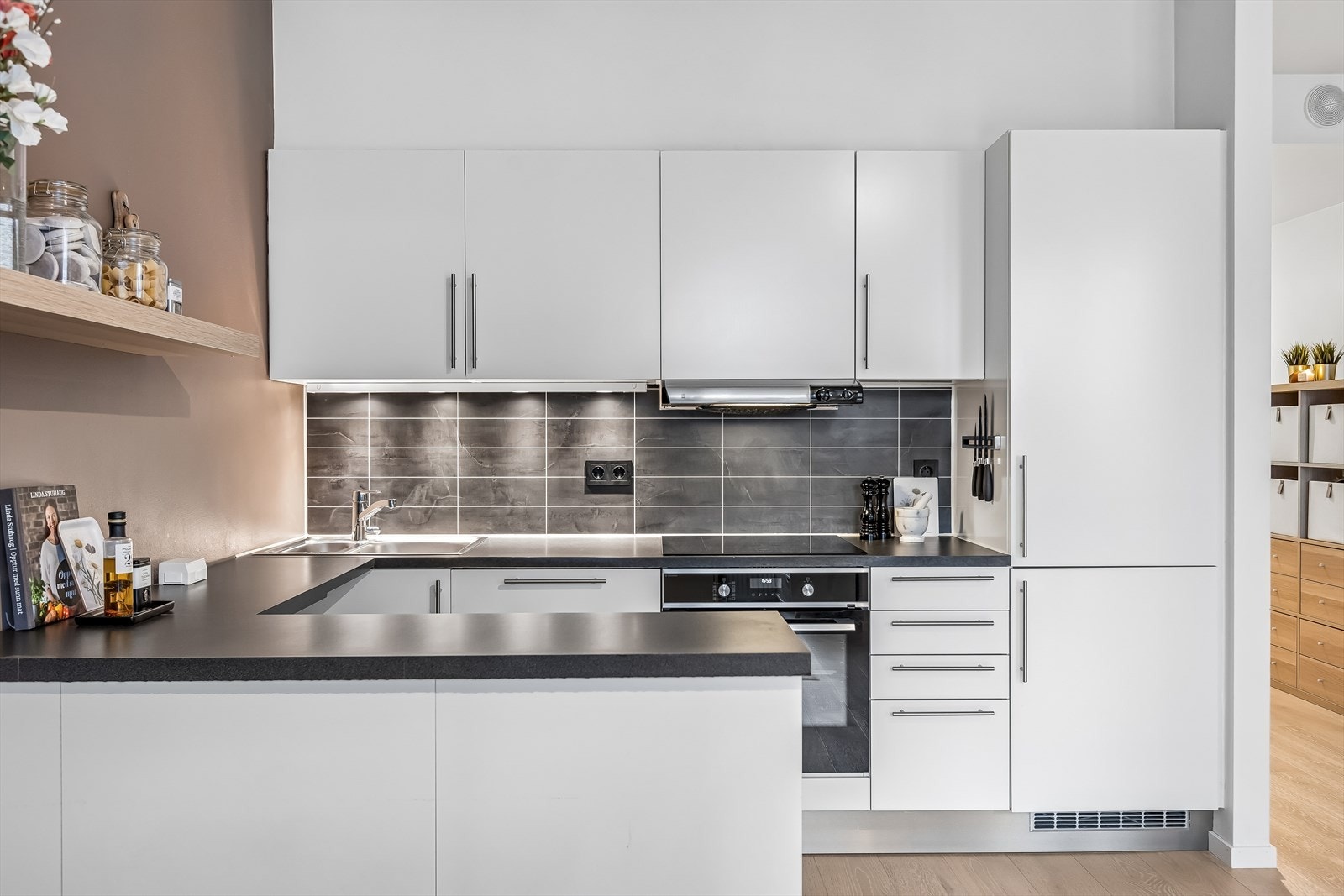 Kjøkkenet er integrert med hvitevarer som kombiskap, stekeovn, oppvaskmaskin og platetopp. Galleribilde