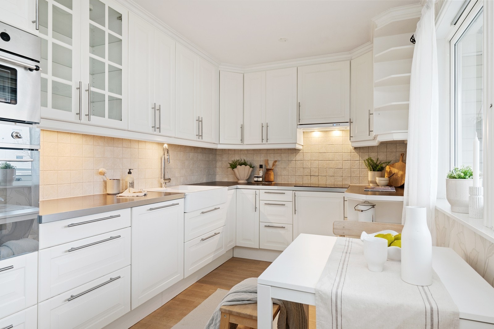 Kjøkkeninnredning med profilerte fronter, laminat benkeplate og integrerte hvitevarer. Galleribilde