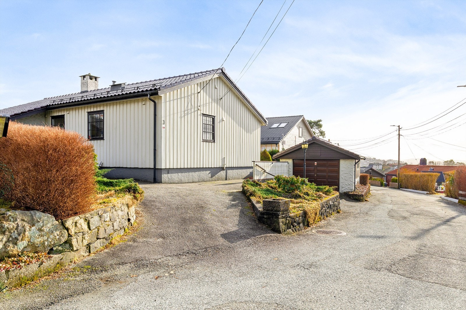 Asfaltert oppkjørsel med biloppstillingsplass og garasje. Galleribilde