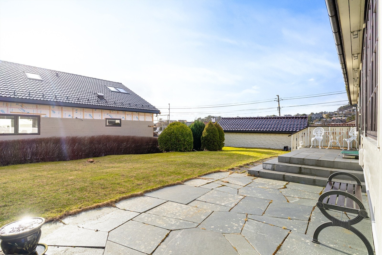 Pent opparbeidet hage med stort plenareal og hellebelagt platting. Her kan fine sommerdager nytes til langt på kvelden. Galleribilde