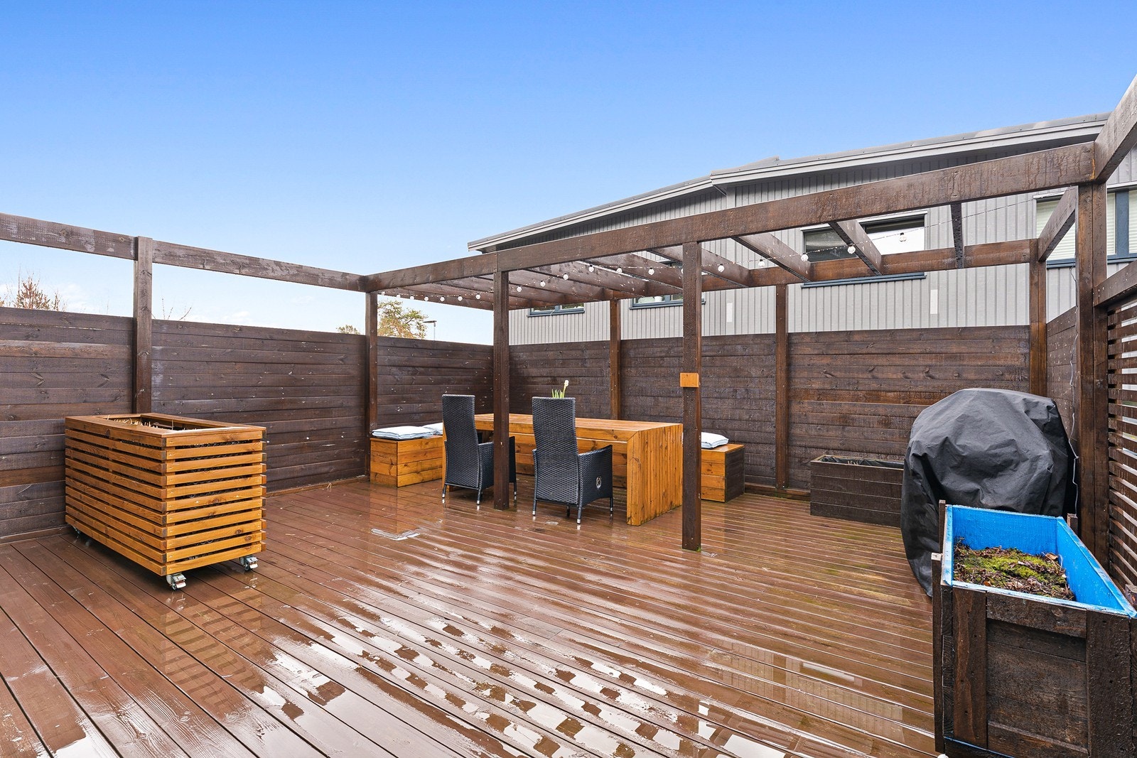 Skjermet uteplass med plass til flere sittegrupper, utegrill og beplantning Galleribilde