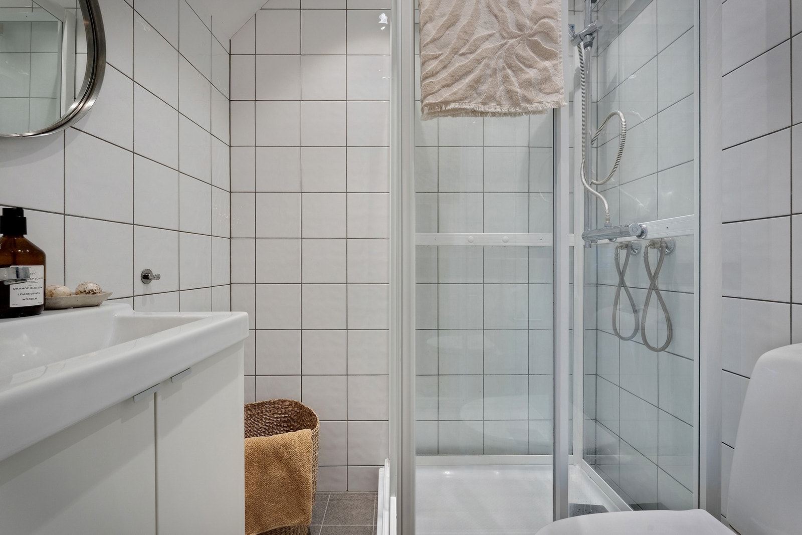 - Badet er lyst og klassisk innredet med fliser på gulv og vegger, og inneholder dusjkabinett, servant og toalett - Galleribilde