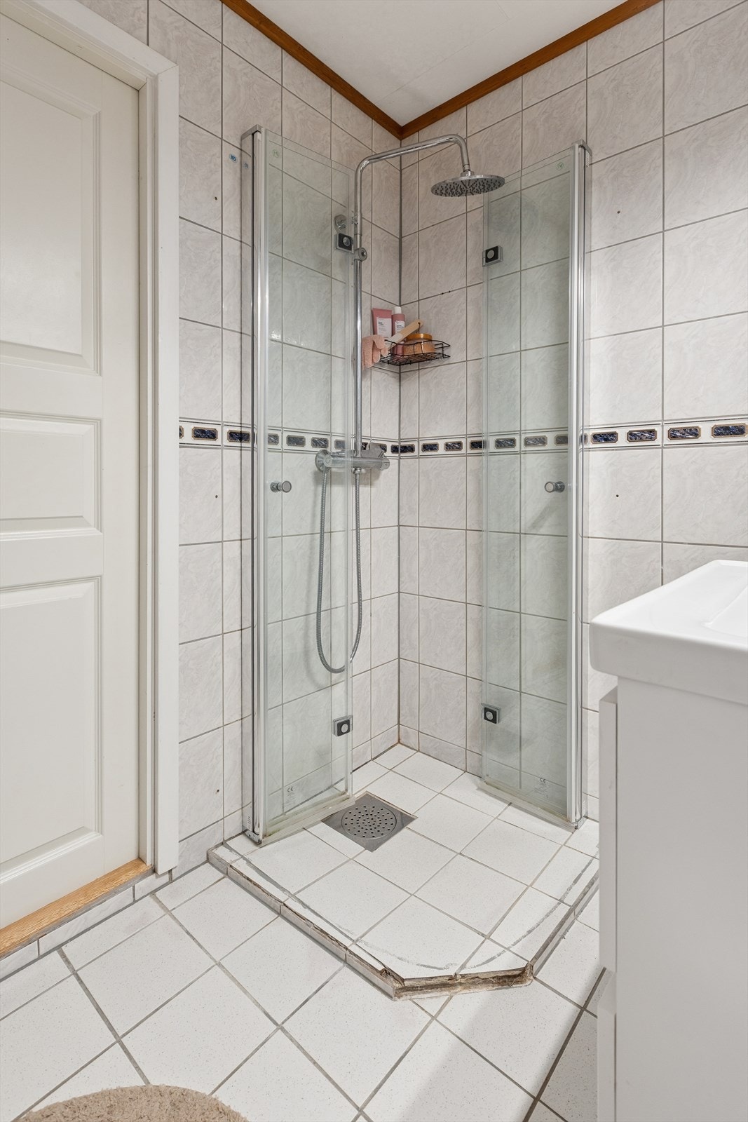 Badet er utstyrt med dusjhjørne med regndusjarmatur, gulvstående toalett og en moderne baderomsinnredning. Galleribilde