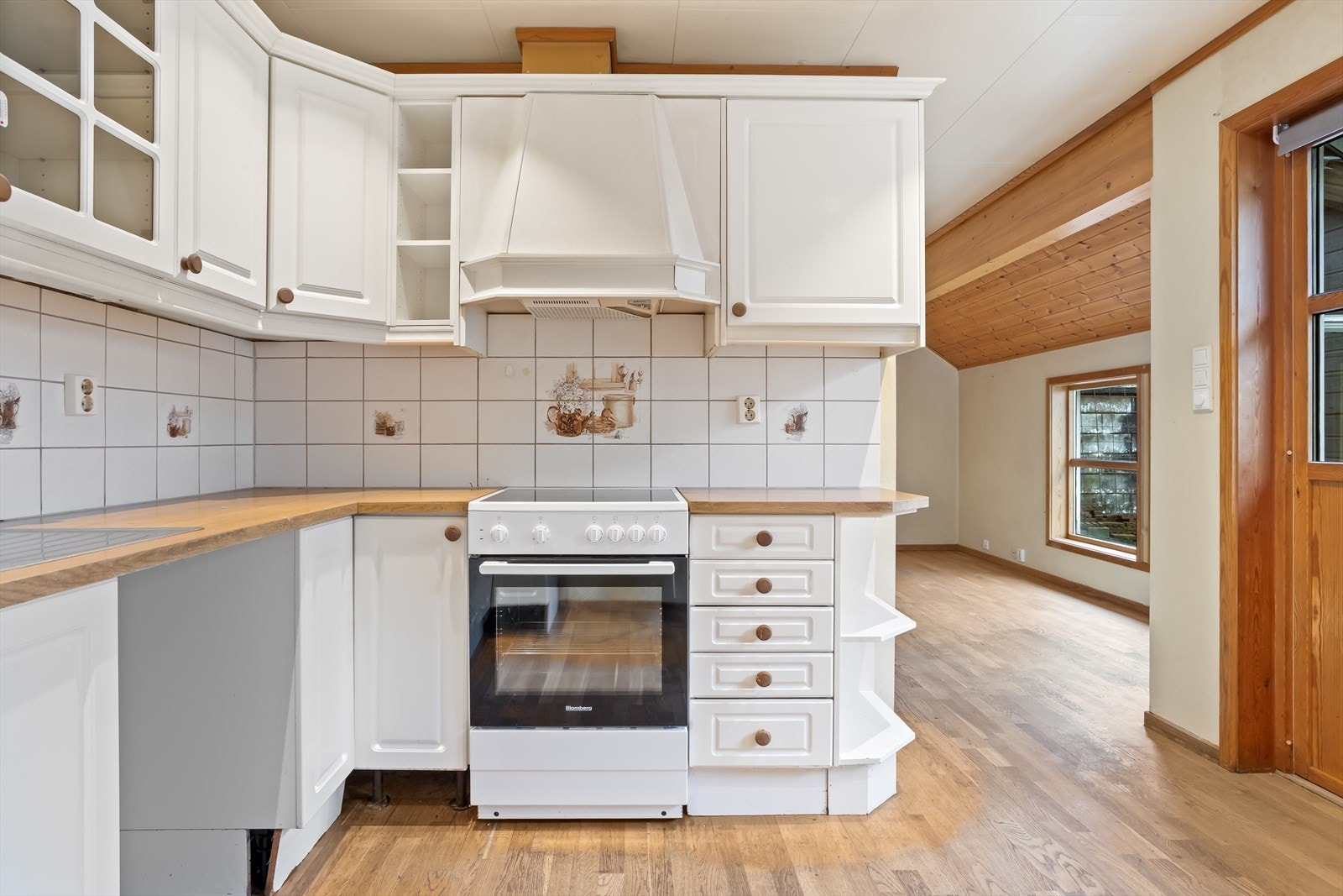 Kjøkkenløsningen gir rom for spisebord, samt en utgang mot boligens hage. Galleribilde