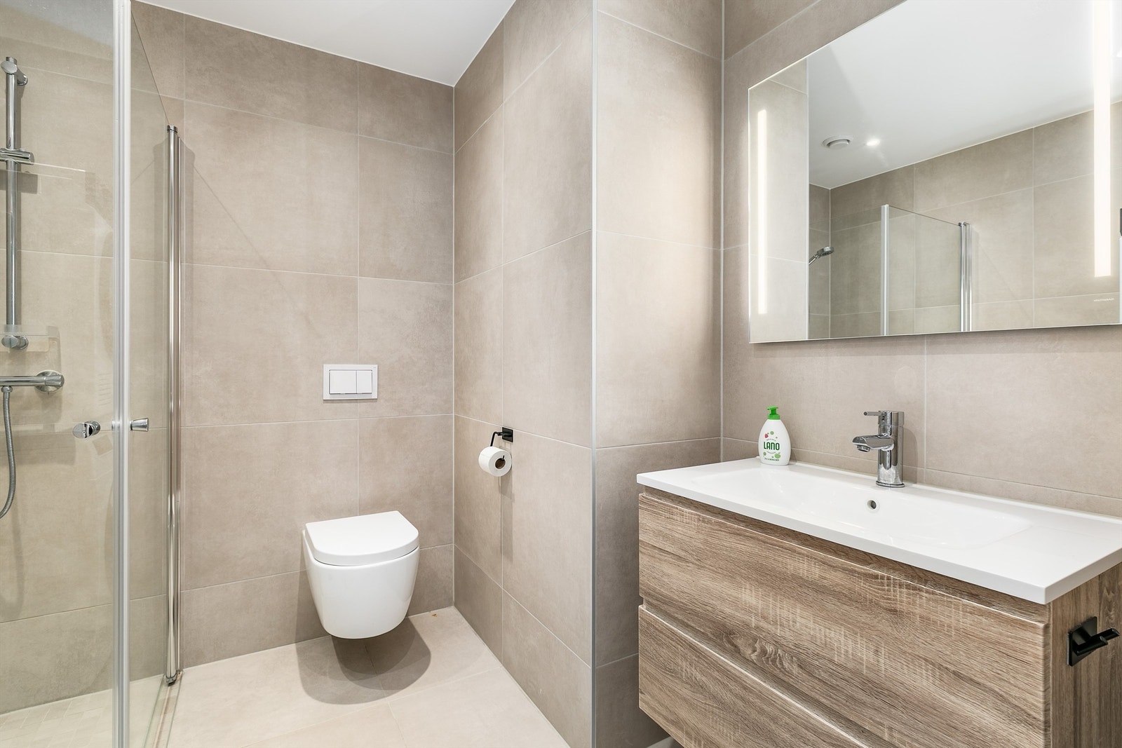 Badet har tidsaktuelle fliser av storformat på både gulv og vegger som skaper helhet. Spotter er innfelt i himlingen og kan dimmes. Galleribilde