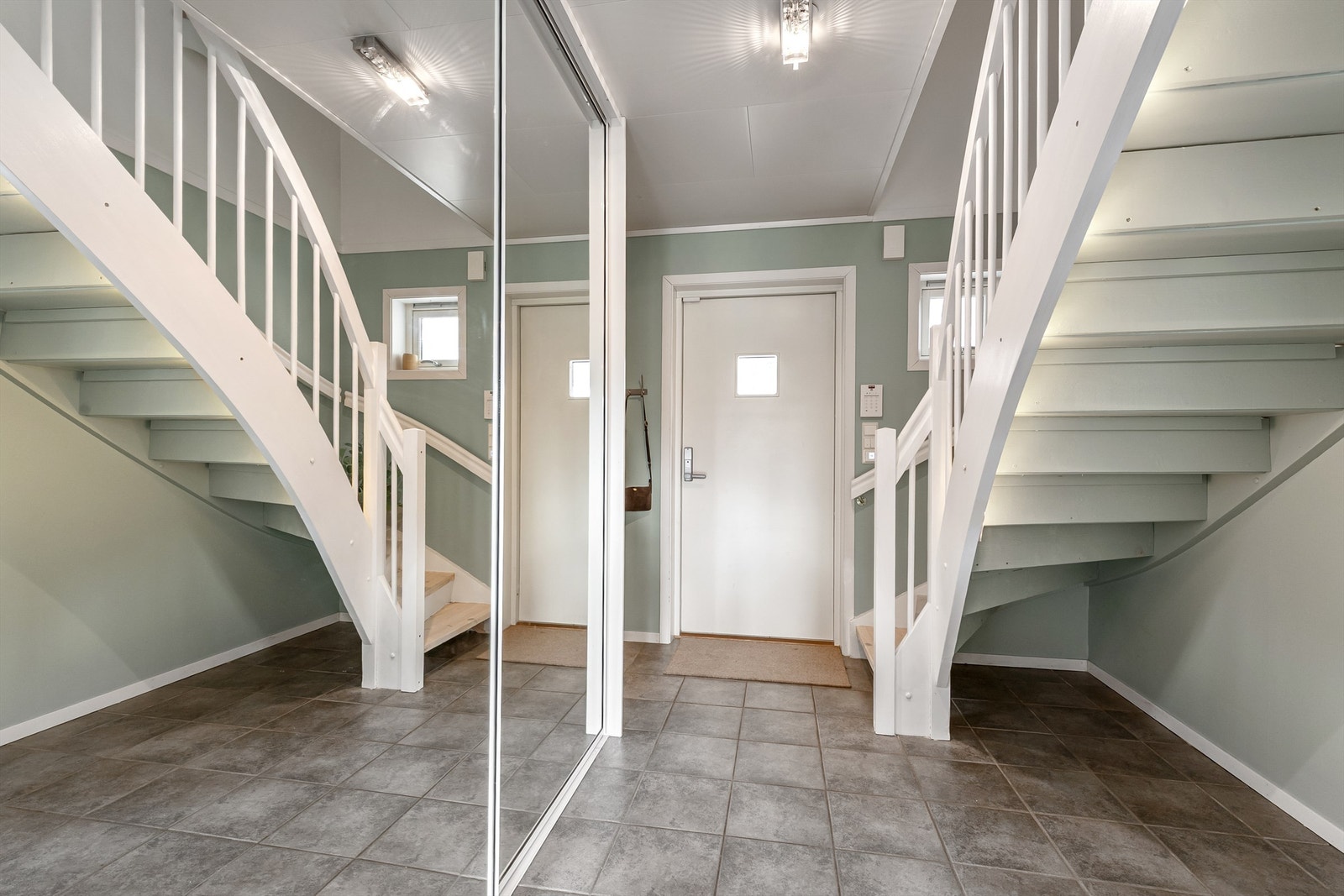 Entréen har flislagt gulv med gulvvarme og en romslig skyvedørsgarderobe med speilfronter for yttertøy og sko. Galleribilde