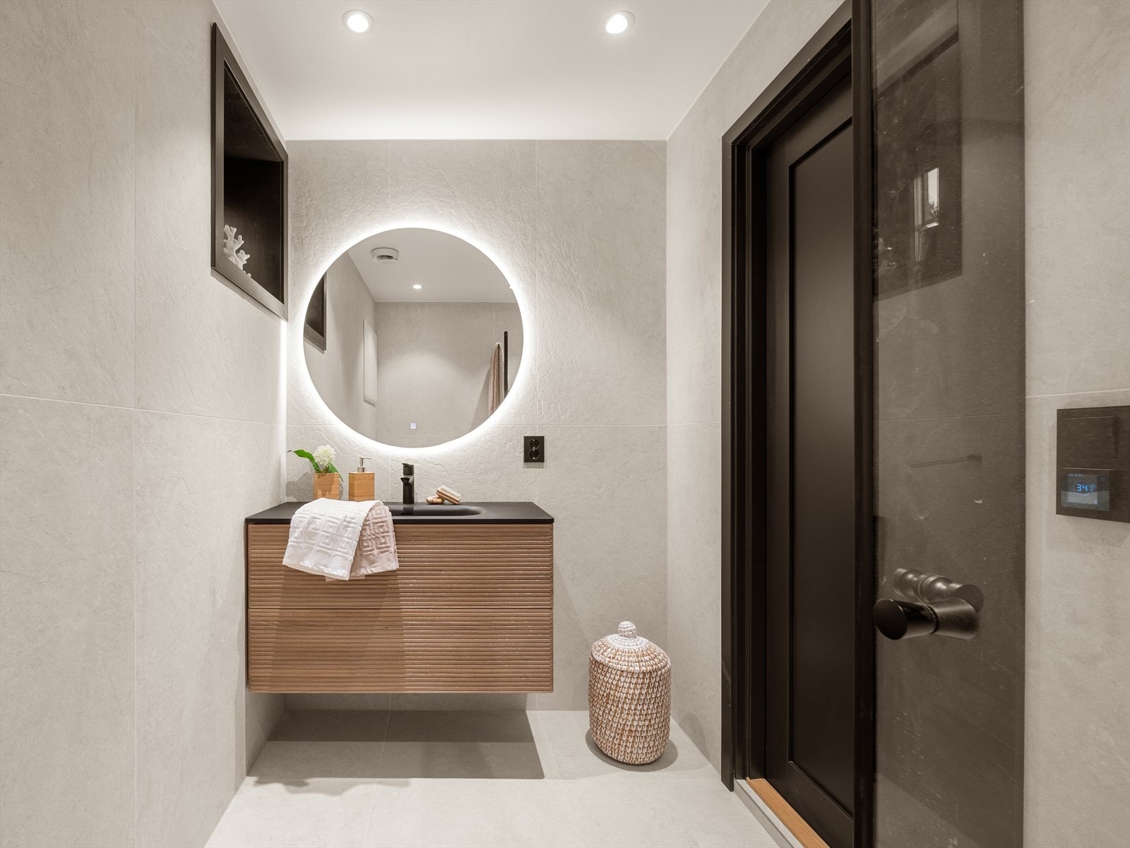 Badet er lekkert innredet og utstyrt med innredning med nedfelt servant, veggmontert toalett og dusjhjørne med glassvegger Galleribilde