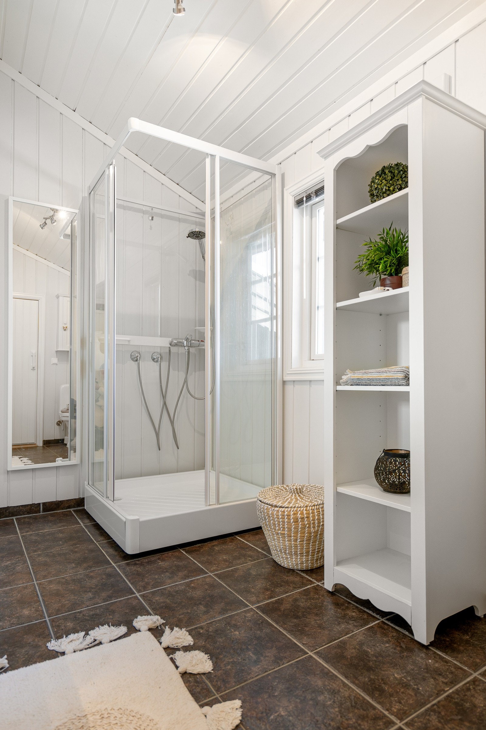 Badet er innredet med servant med skap, dusjkabinett og WC. Galleribilde