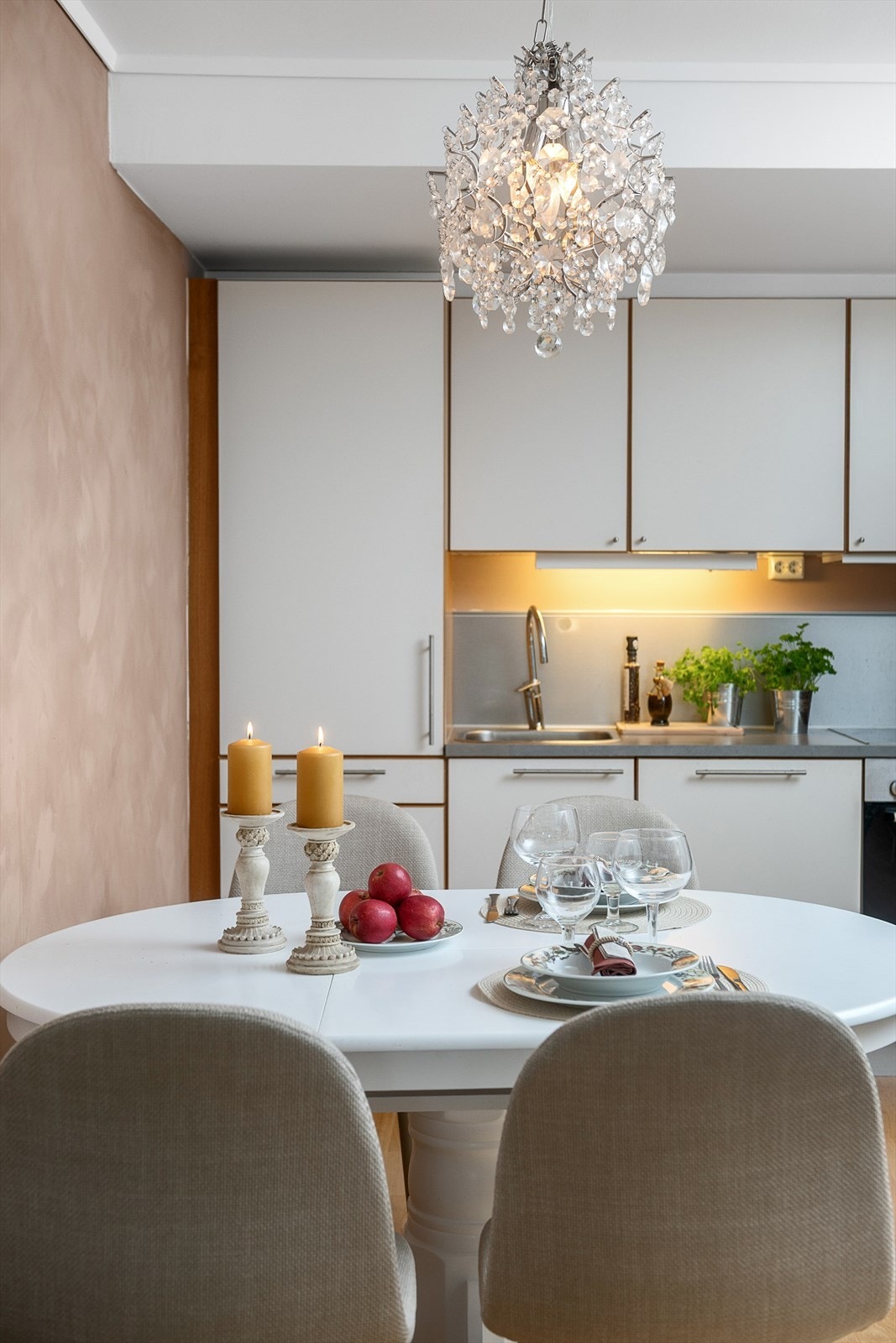 Hvit kjøkkeninnredning med glatte fronter og laminat benkeplate. Integrerte hvitevarer, platetopp med avtrekk og rikelig med oppbevaringsplass. Galleribilde