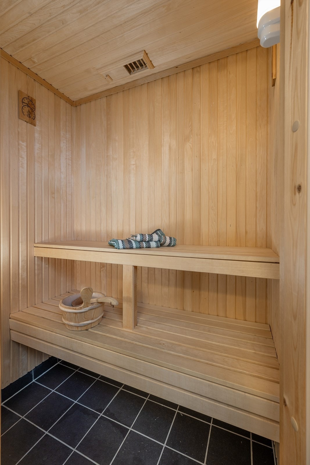 Badestue med fliser på gulv og trepanel på vegg og tak. Galleribilde