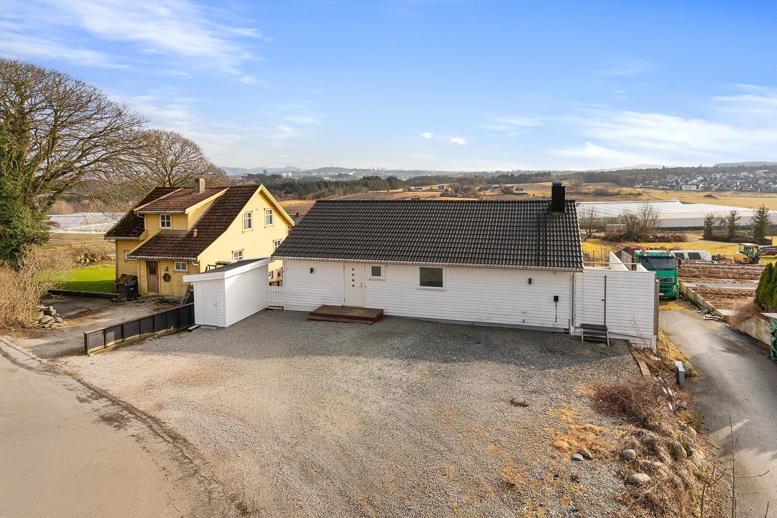 Eiendommen har en romslig, gruset gårdsplass med gode parkeringsmuligheter, frittstående utebod og installert elbillader. Galleribilde