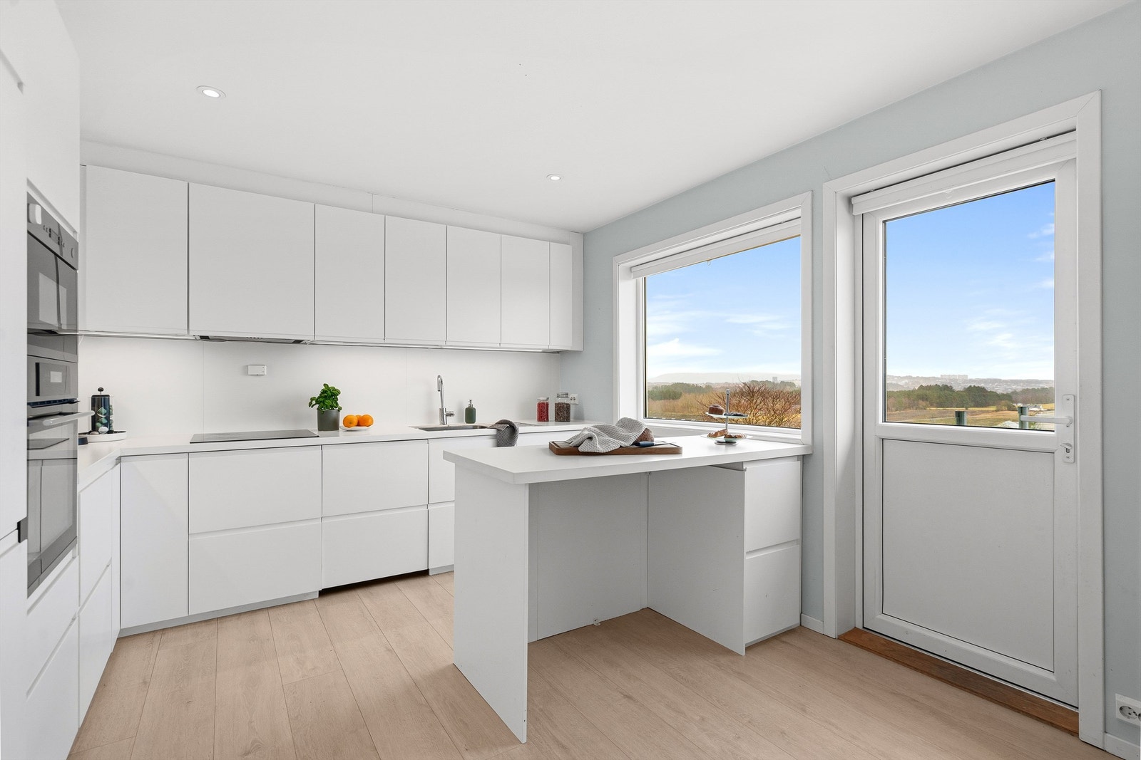 Stilrent og moderne kjøkken fra 2018 med glatte fronter, kjøkkenøy og godt med benkeplass. Galleribilde