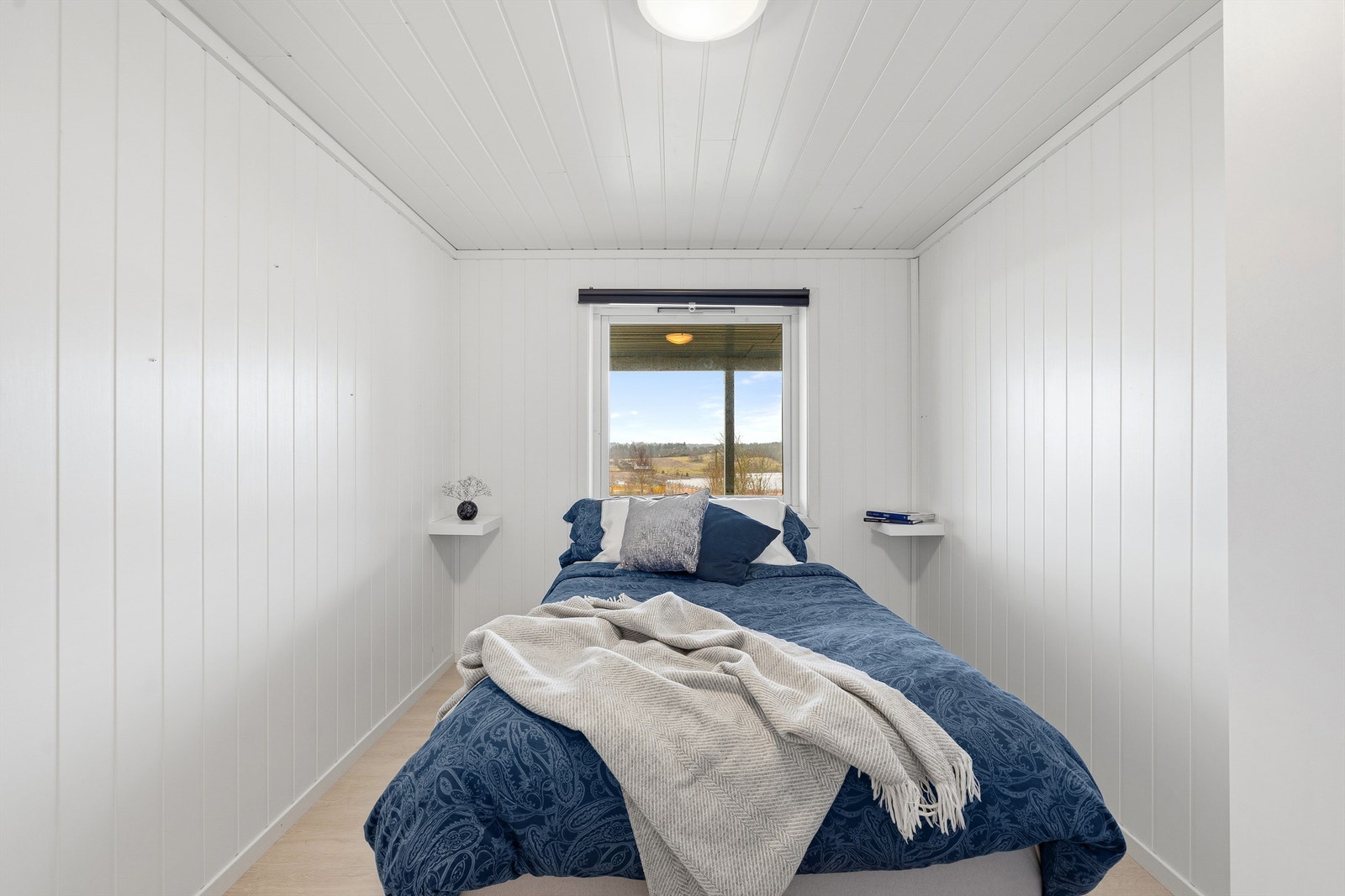 Soverom med malt panel på vegger og plass til seng og garderobeskap. Galleribilde