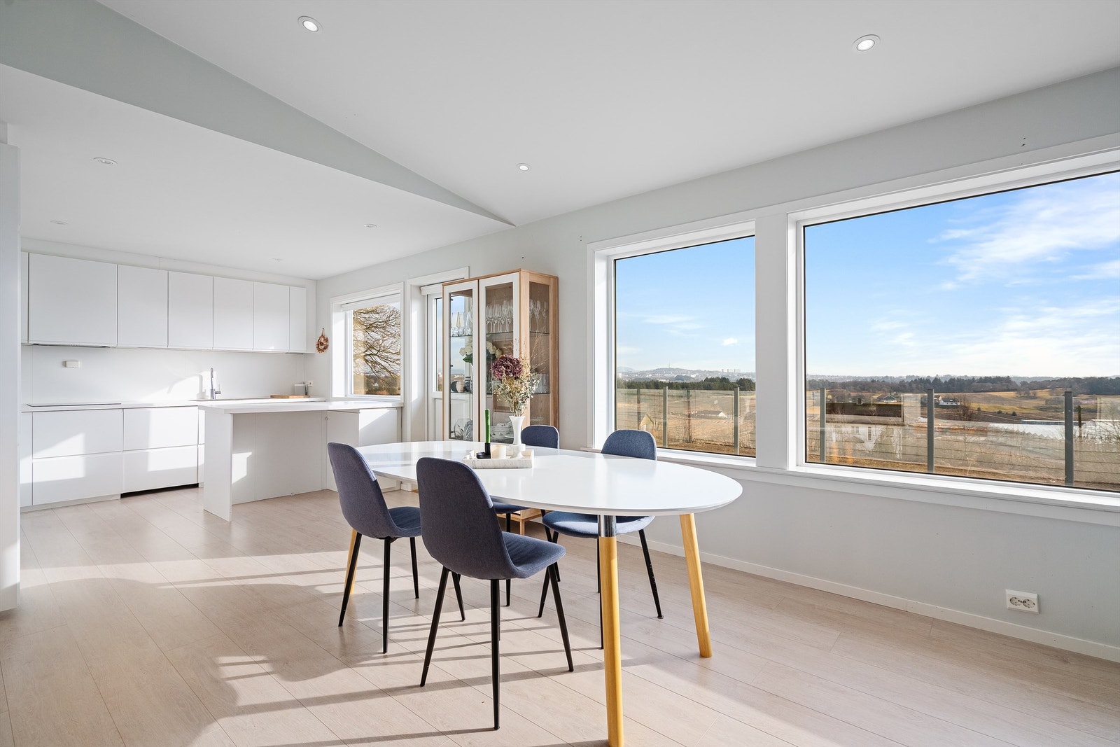 Det åpne allrommet kombinerer kjøkken og stue, med store vindusflater som gir en flott utsikt over landskapet. Galleribilde