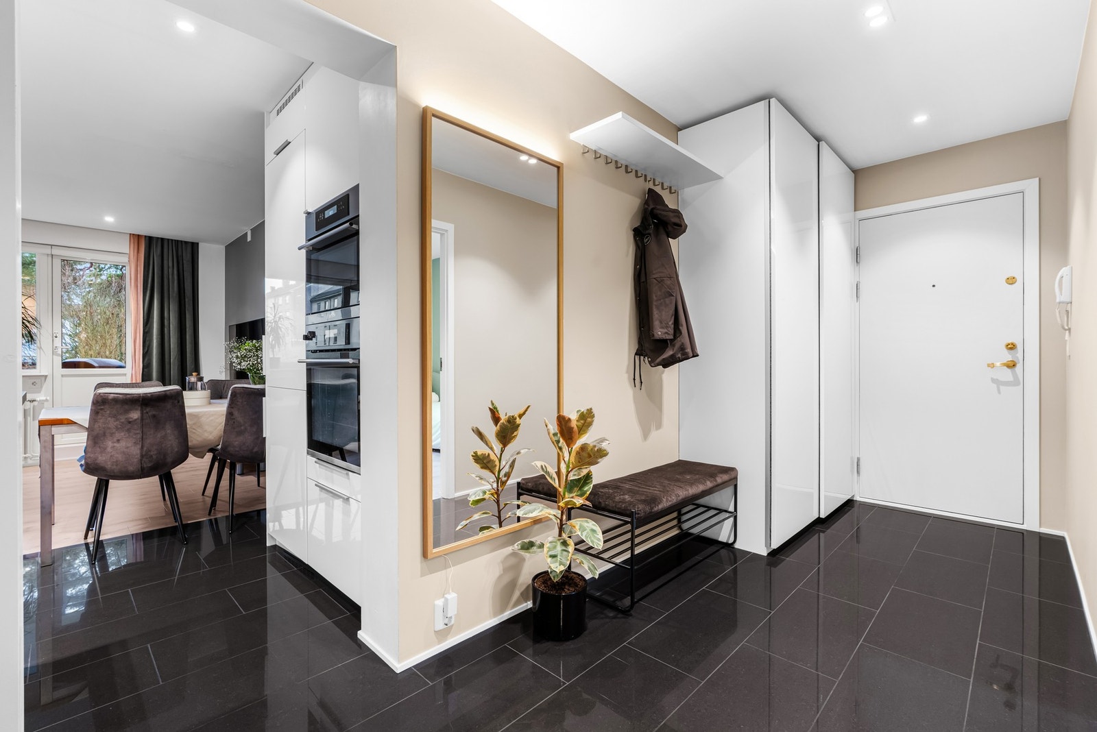 Romslig og flislagt entré med med downlights og praktisk skyvedørsgarderobe for sko og yttertøy. Galleribilde