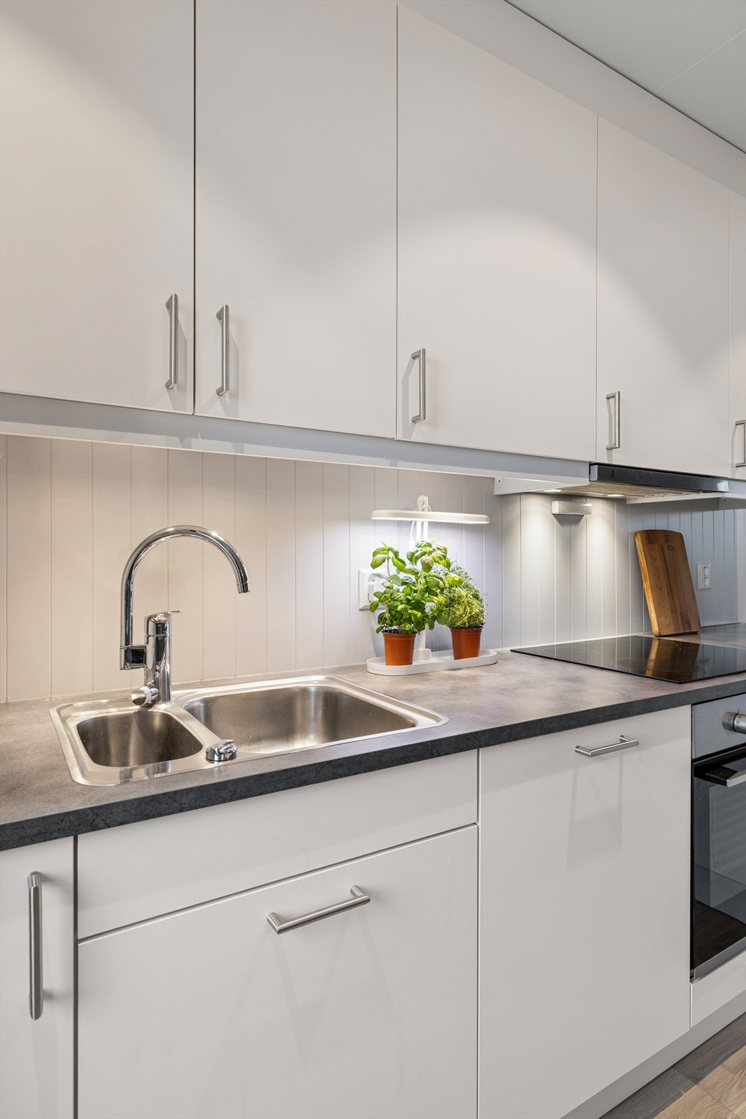 Det er integrerte hvitevarer som oppvaskmaskin, komfyr, induksjonstopp og plass til frittstående kjøleskap. Galleribilde