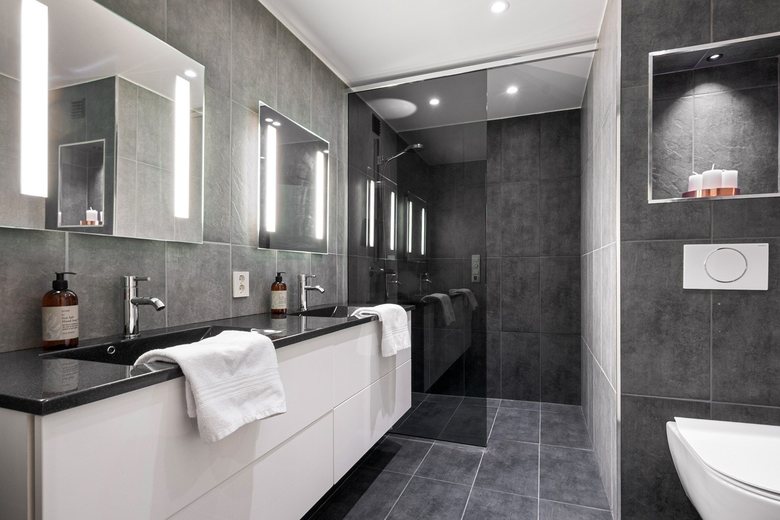 Lekkert bad fra 2022 med gulvvarme, JKE møbel med dobbel servant og stor dusjnisje med glassvegg. Galleribilde