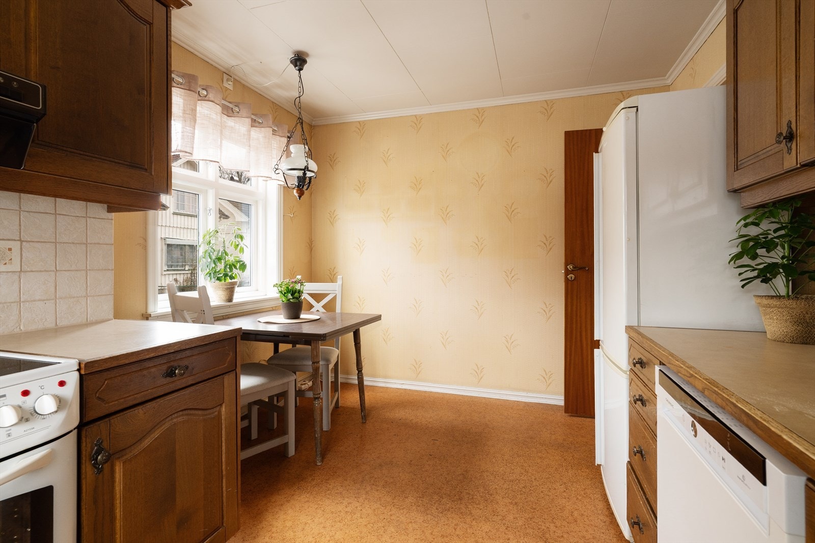 Kjøkkenet i hybelen har en koselig spiseplass ved vinduet. Galleribilde