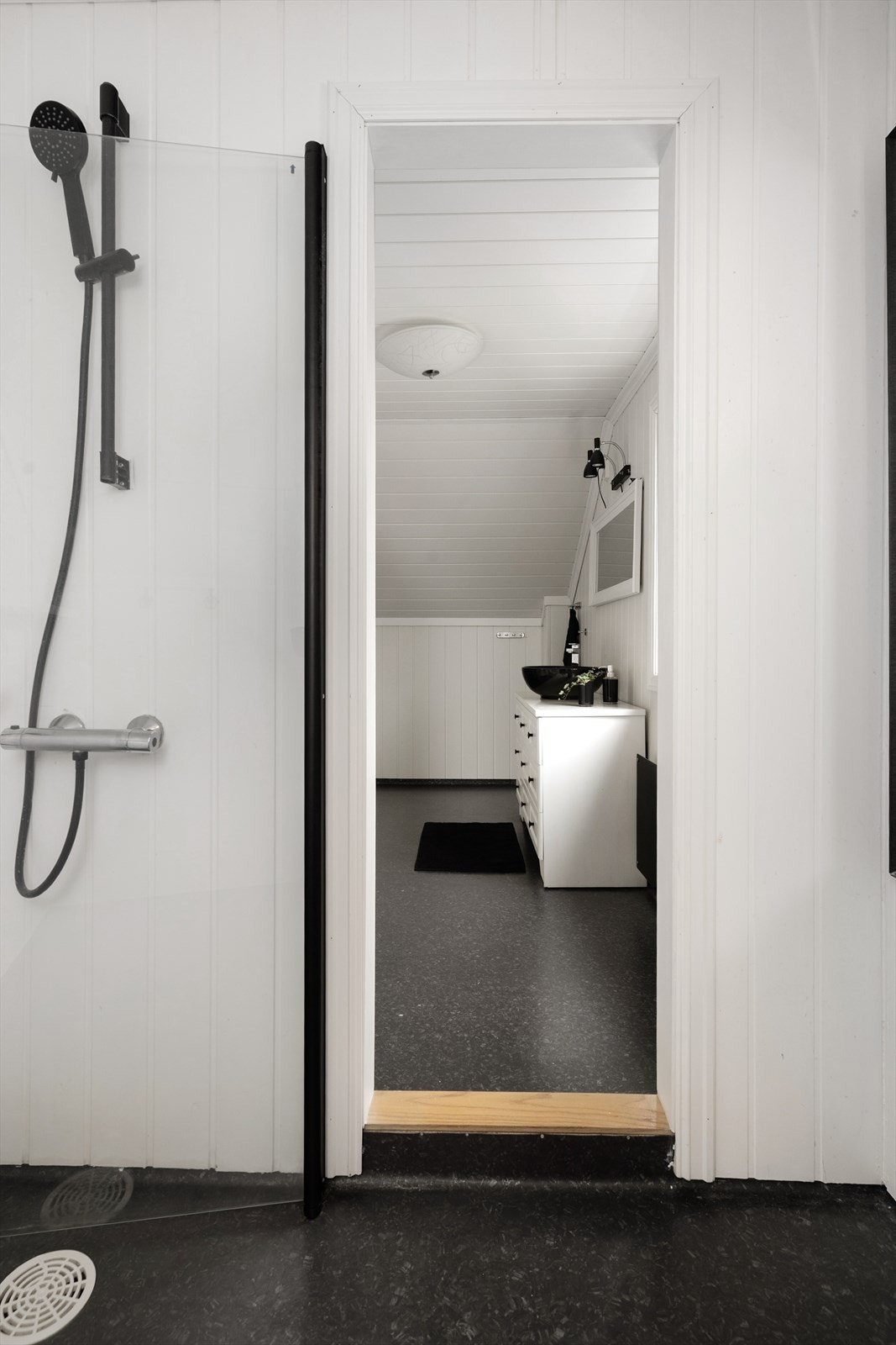 Badet har eget dusjrom hvor det er glassvegg med sorte profiler og sort dusjgarnityr. Det er iflg. eier benyttet vannfaste plater i dusjrommet. Galleribilde