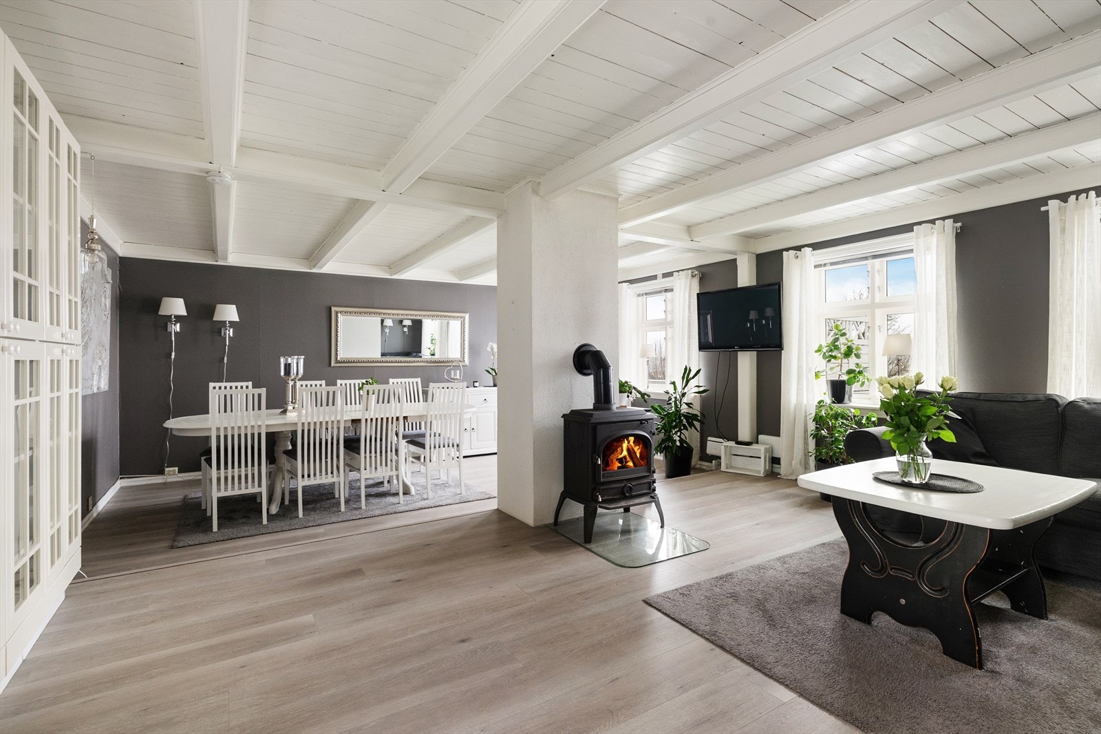 Sentralt i stua er det installert vedovn med glassdør for maksimal peiskos, med glassplate på gulvet. Galleribilde