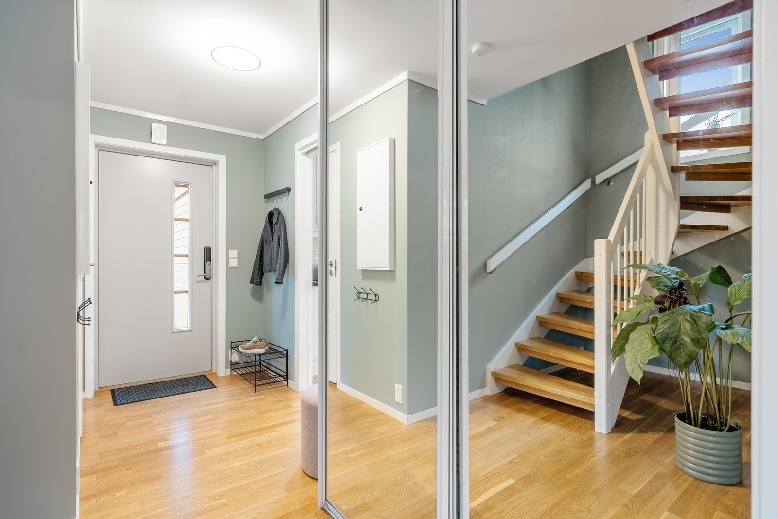 Romslig entré med skyvedørsgarderobe med speildører, som gir en følelse av et større og mer åpent rom Galleribilde